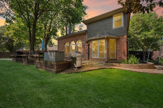 Back of property at dusk featuring a patio area, brick siding, a chimney, and a wooden deck | Image 34