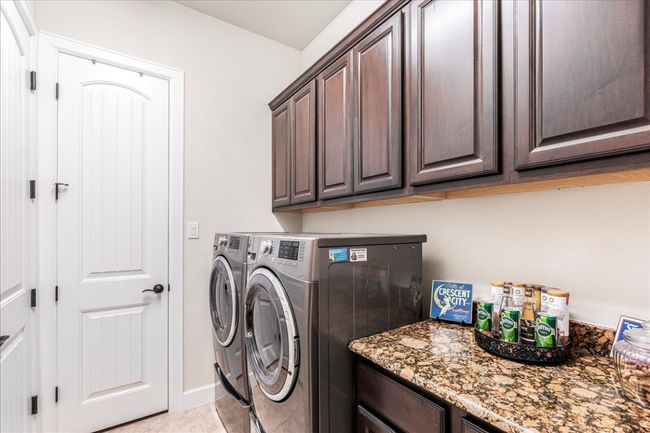 Laundry room featuring cabinet space, washing machine and clothes dryer, and light tile patterned flooring | Image 27