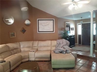 Living room featuring ceiling fan, lofted ceiling, tile patterned flooring, and decorative columns | Image 2