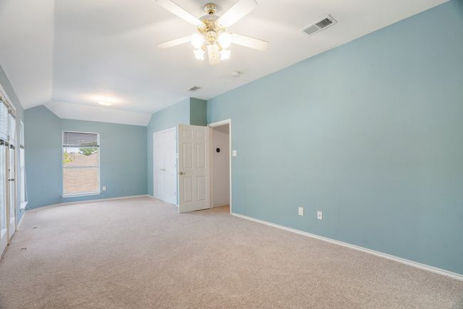 Unfurnished bedroom with baseboards, visible vents, light colored carpet, and vaulted ceiling | Image 24