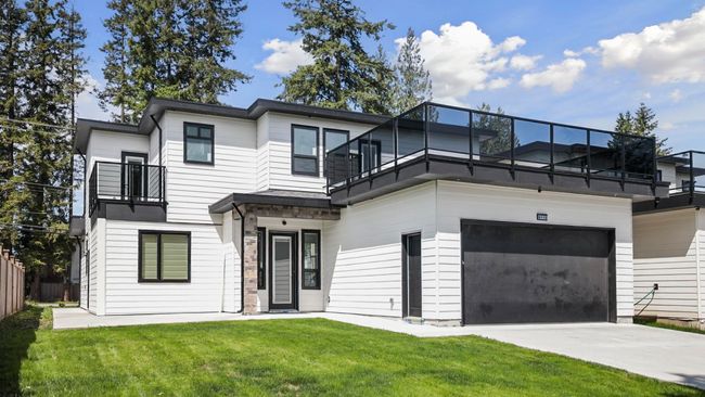 Contemporary house featuring a balcony, driveway, a front lawn, and a garage | Image 25