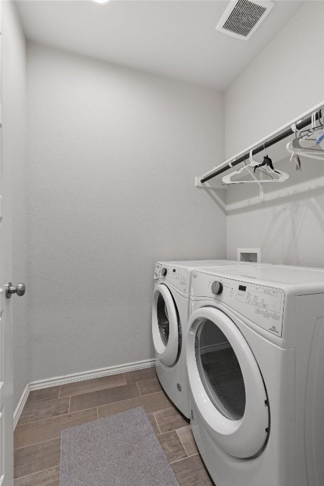 The main level laundry room includes W/D connections and overhead shelving for your laundry needs. | Image 26