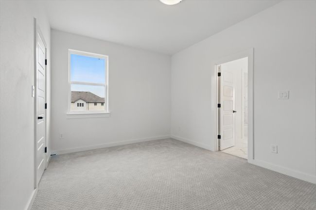 Unfurnished bedroom with carpet flooring, baseboards, and connected bathroom | Image 31