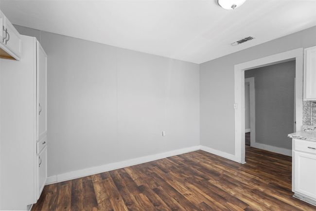 Unfurnished bedroom with dark wood finished floors and baseboards | Image 7