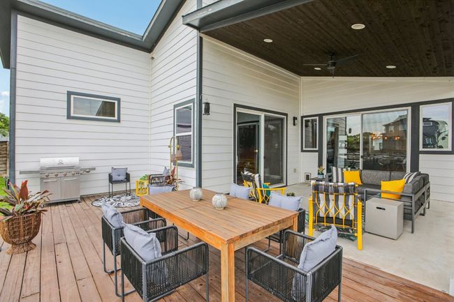 Wooden deck with grilling area, an outdoor living space, a ceiling fan, and outdoor dining area | Image 36