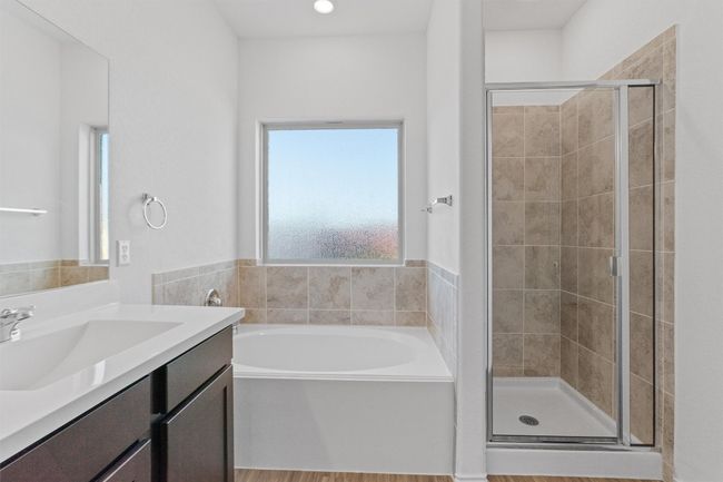 Full bathroom featuring a stall shower, a garden tub, and vanity | Image 15
