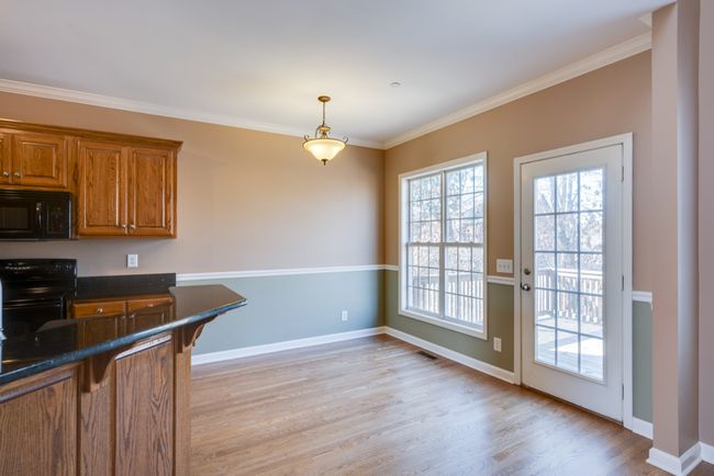 Sunlit eat-in kitchen space with view of private backyard. | Image 14