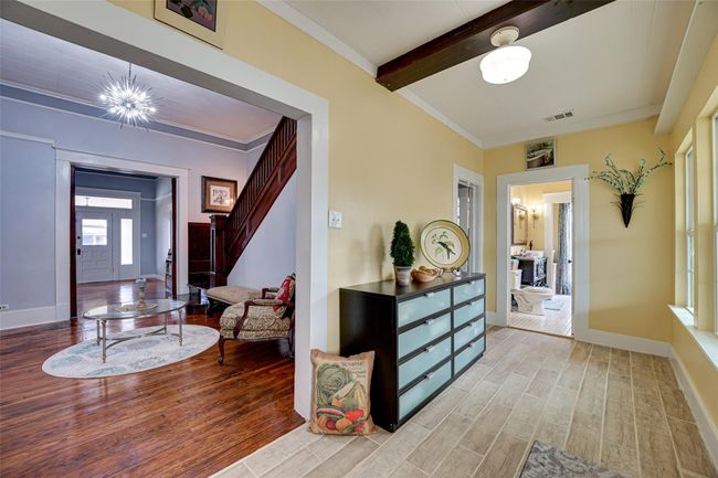 Hallway with light wood-type flooring, baseboards, visible vents, and beamed ceiling | Image 14