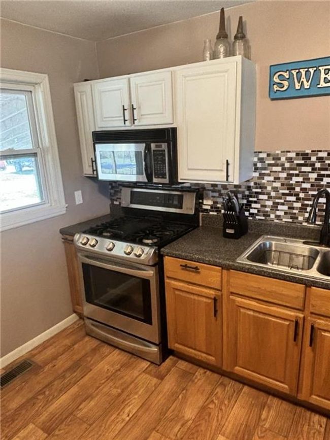 Kitchen with stainless steel range with gas cooktop and laminate flooring | Image 12