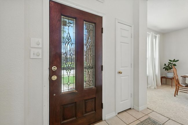 Foyer with light tile patterned floors, healthy amount of natural light, and light carpet | Image 4