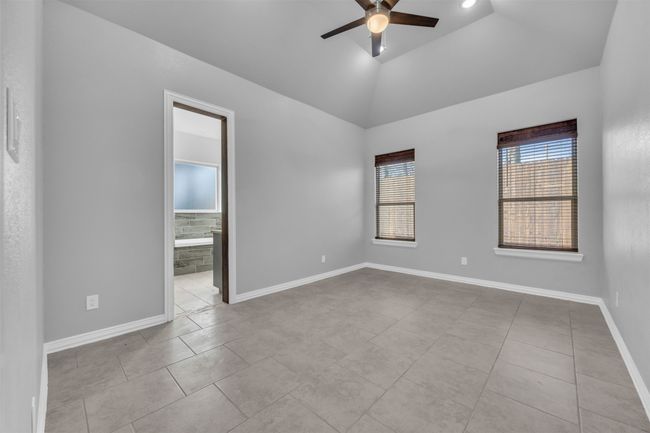 Tiled empty room featuring ceiling fan and lofted ceiling | Image 17