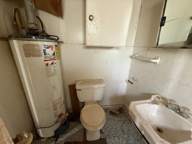 Bathroom featuring gas water heater, a sink, and toilet | Image 16