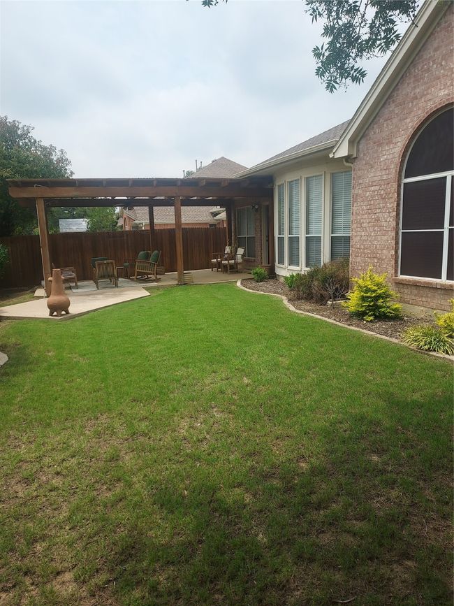 Spacious yard featuring a pergola covered patio area. | Image 32