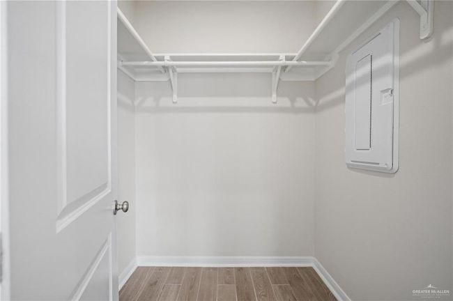 Walk in closet with electric panel and wood finished floors | Image 5