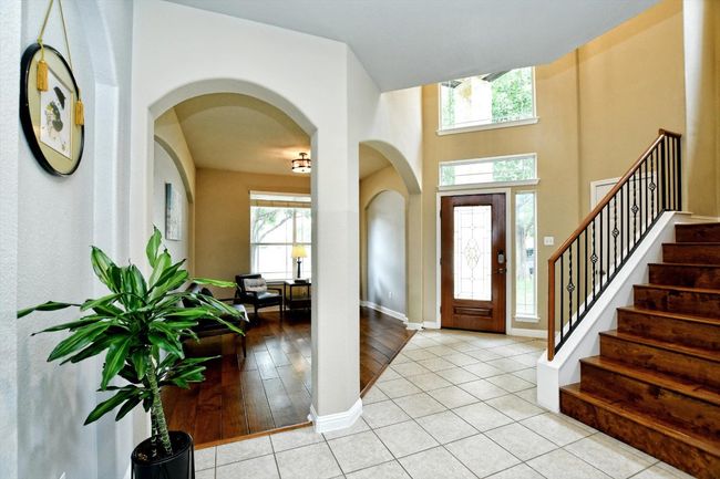 Entrance foyer featuring arched walkways, stairs, baseboards, and light tile patterned flooring | Image 4