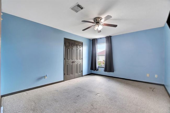 Spacious bedroom featuring a soothing blue palette, large window for natural light, and ample closet space. | Image 39