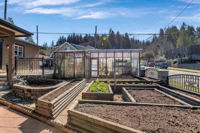 View of yard featuring a greenhouse, a garden, and an outdoor structure | Image 32