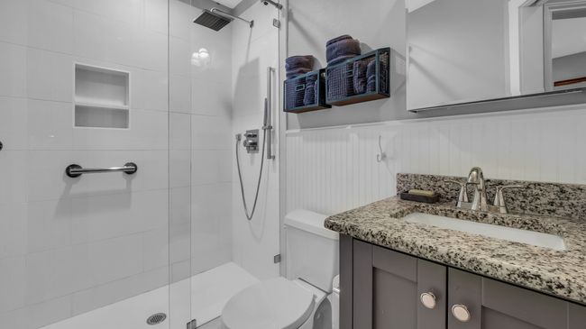 Bathroom with toilet, a shower stall, wainscoting, and vanity | Image 21