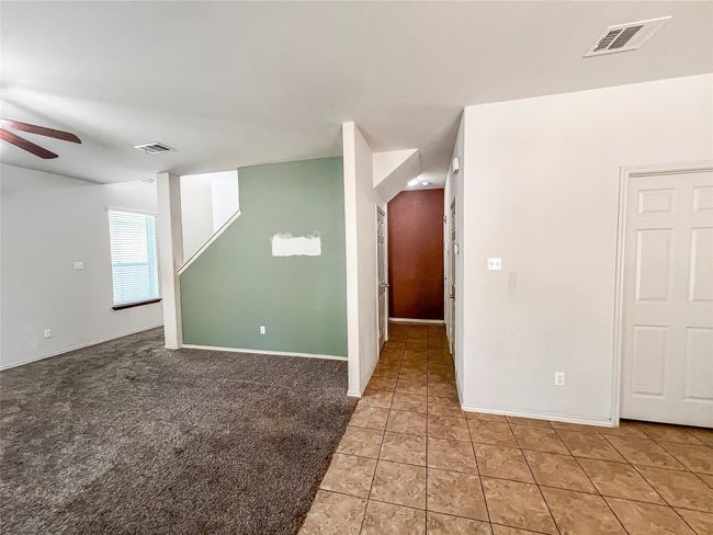 Empty room with a ceiling fan and light tile patterned floors | Image 8