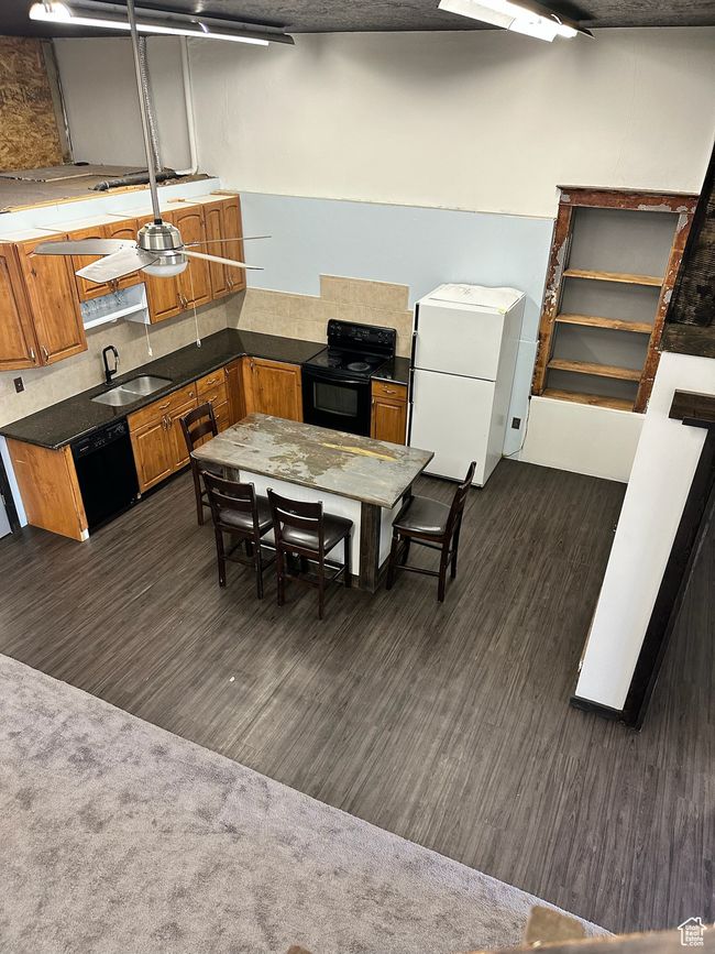 Kitchen with dark colored carpet, sink, and black appliances | Image 15