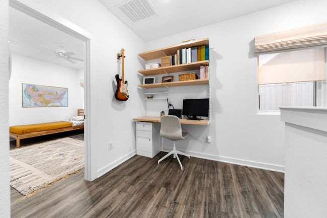 Office featuring built in study area, baseboards, visible vents, ceiling fan, and dark wood-type flooring | Image 26