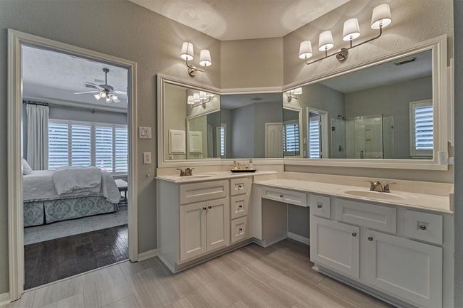 Primary Bath with double sinks, vanity area and plenty of storage. Also includes large walk-in closet. | Image 26