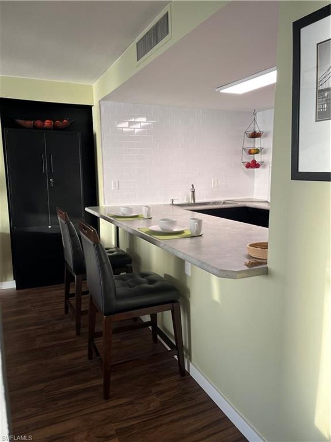 Kitchen featuring wood finished floors, tasteful backsplash, and breakfast bar | Image 6