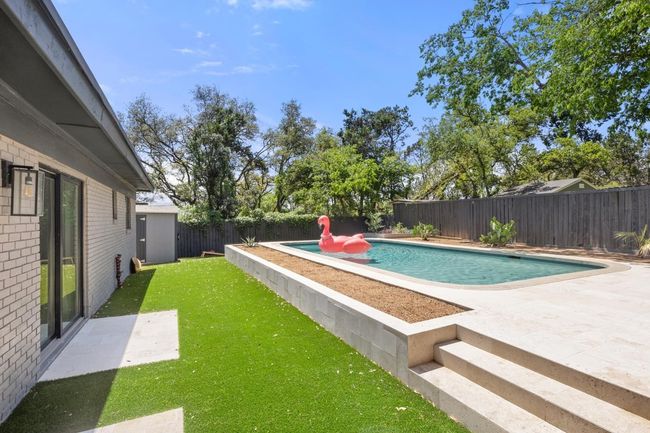 View of pool with a fenced in pool, a patio area, a fenced backyard, and a lawn | Image 33