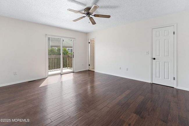 Expansive Primary Suite boats private deck, Full Bath and Walk in Closet plus gleaming wood flooring | Image 12