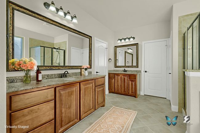 The en-suite master bath features his-and-hers vanities and walk-in closets. | Image 15