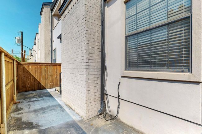 View of side of property featuring a patio, brick siding, and stucco siding | Image 34