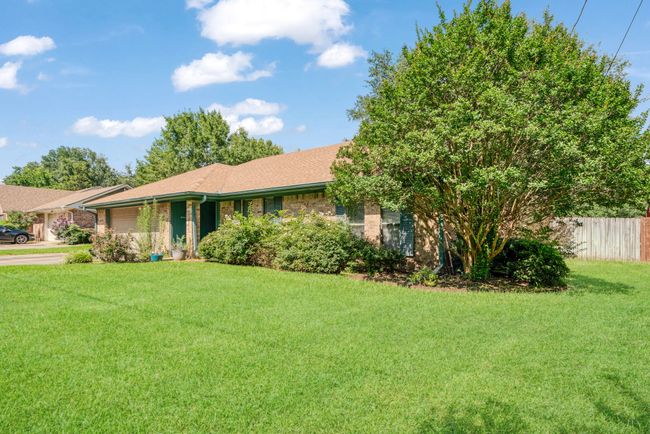 Ranch-style home featuring a garage, brick siding, roof with shingles, and driveway | Image 14