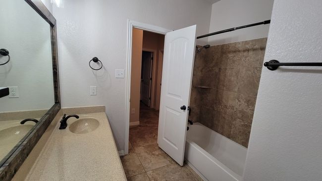 Bathroom with tile patterned floors, vanity, and bathtub / shower combination | Image 10