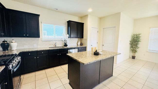 Kitchen with dark cabinets, light tile patterned floors, healthy amount of natural light, and recessed lighting | Image 17