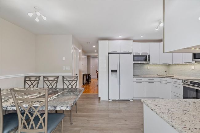 Kitchen featuring white cabinets, recessed lighting, light wood-style flooring, tasteful backsplash, and appliances with stainless steel finishes | Image 18