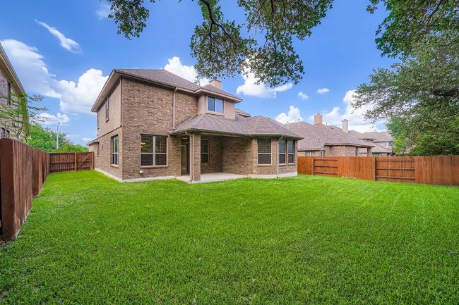Back of property with a patio, a fenced backyard, brick siding, roof with shingles, and a chimney | Image 26