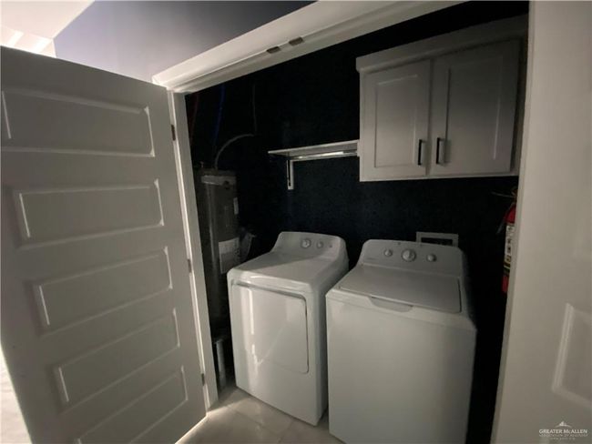 Laundry room featuring cabinet space and washer and clothes dryer | Image 10