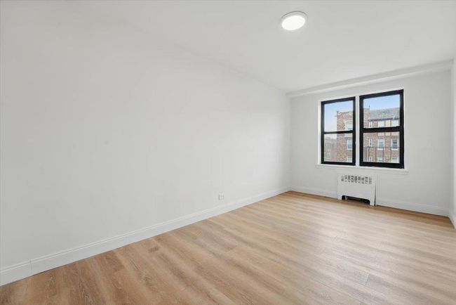 Spare room with radiator, light wood-style floors, and baseboards | Image 18