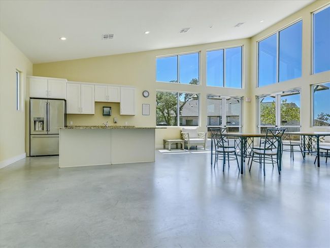 Kitchen with high end fridge, a high ceiling, white cabinets, plenty of natural light, and recessed lighting | Image 33