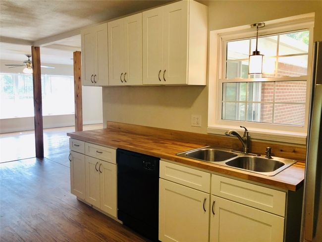 Kitchen with butcher block countertops, dishwasher, a ceiling fan, and white cabinetry | Image 10