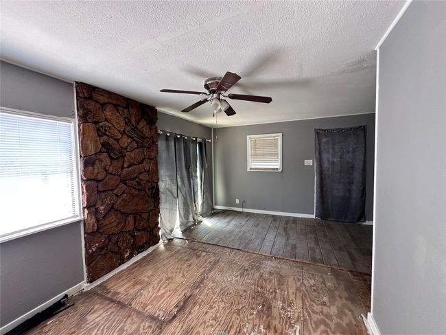 Unfurnished room featuring wood-type flooring, ceiling fan, baseboards, and a textured ceiling | Image 12