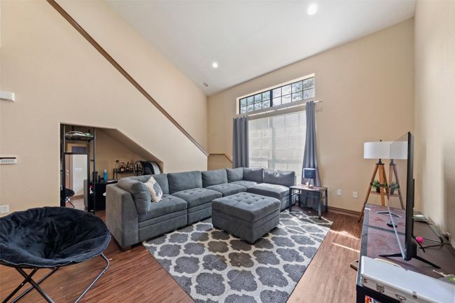 Living room with wood finished floors, a high ceiling, and recessed lighting | Image 10