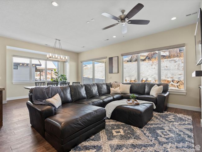 Living room featuring wood finished floors, baseboards, ceiling fan, recessed lighting, and a chandelier | Image 13