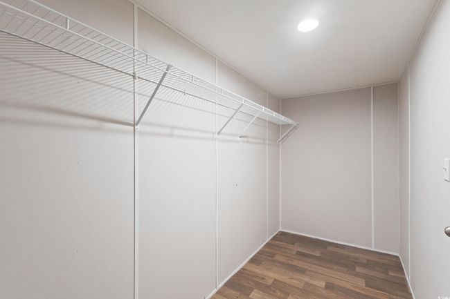 Spacious closet with wood finished floors | Image 35