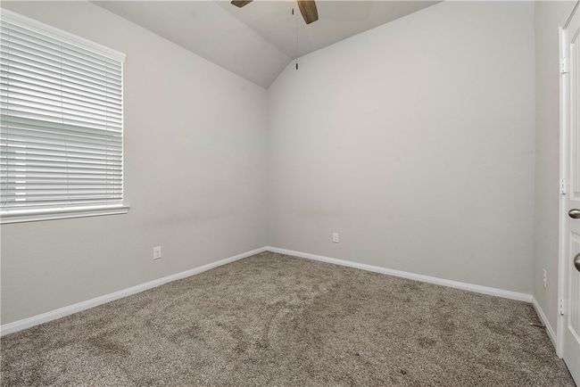 Carpeted empty room with ceiling fan and lofted ceiling | Image 16