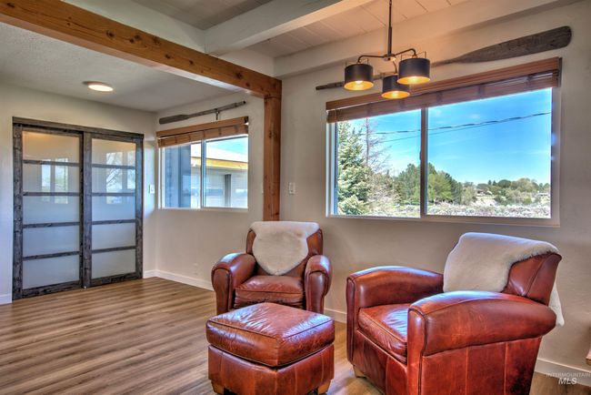 Sitting room with beam ceiling and wood finished floors | Image 9