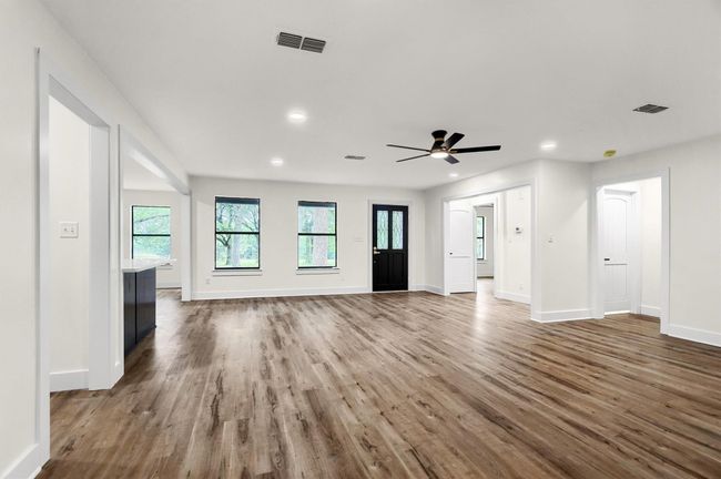 Unfurnished living room with wood finished floors, baseboards, recessed lighting, and a ceiling fan | Image 7