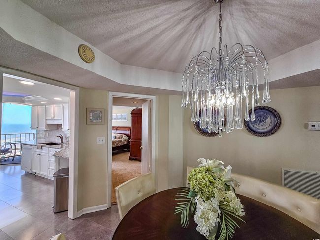 Dining area featuring a chandelier, tile patterned floors, and a textured ceiling | Image 16