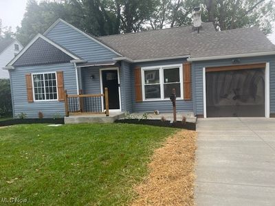 View of front of property with a front yard and a garage | Image 1