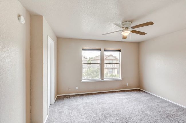 Spare room with a ceiling fan, carpet, a textured ceiling, and a smoke detector | Image 11